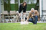 Couple playing with their pets in a garden