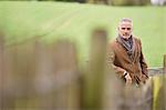 Man standing by fence in a field