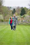 Homme qui marche avec sa fille dans un champ