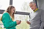 Homme et fille à l'aide de leur téléphone mobile