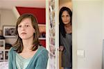 Woman watching her daughter behind the door in the bedroom