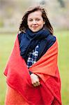 Portrait d'une jeune fille, enveloppé dans une couverture et souriant