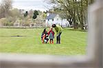 Two women convincing a displeased girl in a park