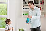 Man showing sparkling water bottle to his son