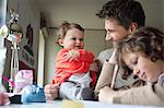 Close-up of a man with his children at home