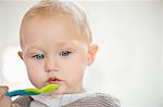 Close-up of a baby girl holding a spoon