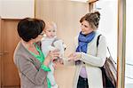 Woman showing a teddy bear to a baby girl