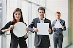 Business executives holding blank placards in an office