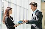 Businessmen giving files to his female colleague in an office