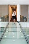 Geschäftsfrau Gespräch auf ein Mobiltelefon in ein Büro-Korridor