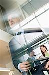 Reflection of business executives on window glass