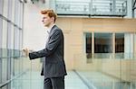 Businessman looking through glass window in a corridor