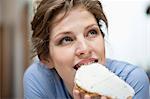 Femme mange un toast avec propagation crème dessus