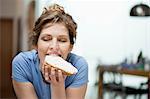 Close-up of a woman eating toast with cream spread on it