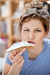 Portrait of a woman eating toast with cream spread on it