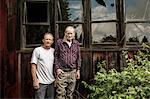 Father and son outside shack, portrait