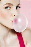 Young woman blowing bubblegum