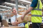 Man delivering cardboard box to another man