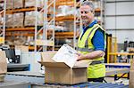 Man packing clothing into cardboard box