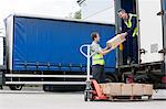 Two men unloading cardboard boxes from truck