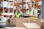 Two men checking stock in warehouse