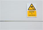 Surveillance camera sign on warehouse door