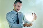 Businessman holding ball of light