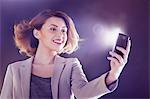 Young woman looking at cellphone with lights