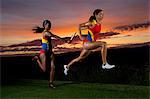 Female relay racers passing baton