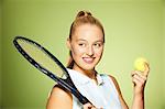 Jeune femme avec une raquette de tennis et balle de tennis
