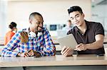 Young men in break room with digital tablet