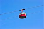Cable car in mountains on blue sky background