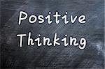 Positive thinking written with white chalk on a smudged blackboard background