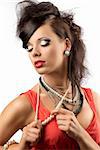 pretty brunette with fashion hair style, red dress and some necklaces. She is turned of three quarters at right, looks down and touches her pearl necklace with both hands