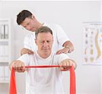 Physiotherapy: Senior man doing exercise under supervision of physiotherapist