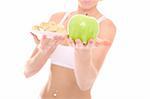 A picture of a young fit woman offeringa green apple instead of cookies over white background