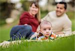 Happy Mixed Race Baby Boy and Parents Playing Outdoors in the Park.