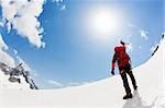 A male mountaineer expresses his joy reaching the summit of a snowed mountain peak. Mont Blanc, Chamonix, France.