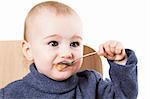 baby eating applesauce - studio shot isolated on white background