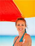 Smiling woman applying sun block creme on arm