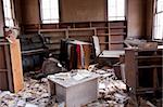 Trashed room with old furtinure and papers scattered about.