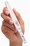 Hand holding positive result pregnancy test, against white background. You can easily set to negative result by patching the area around the 'T' so only the 'C' area has red strip