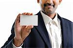 Mature Asian Indian businessman holding business card, focus on hand over white background