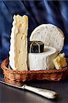 Assortment of cheese in a wicker basket.