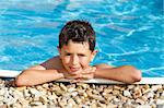 smiling boy in the swimming pool with clear water