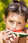 wet boy with watermelon in the garden after swimming
