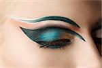 girl's eye closeup with creative green makeup, it's closed