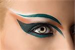 girl's eye closeup with creative green makeup. it's open