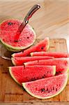 fresh ripe watermelon sliced on a  wood table with knife