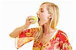 A young woman biting into a green apple